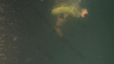 女孩充气环游泳黑暗脏池粒子水下慢运动视图